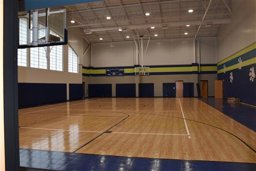 Inside gym view of the floor and overhead basketball goals